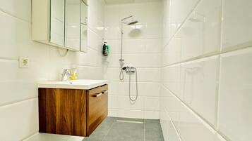 Eenvoudig appartement | Badkamer | Een douche, gratis toiletartikelen, handdoeken, zeep