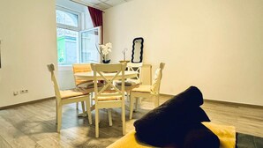 Une pièce comprenant une table à manger, des chaises, un miroir et un tapis jaune.