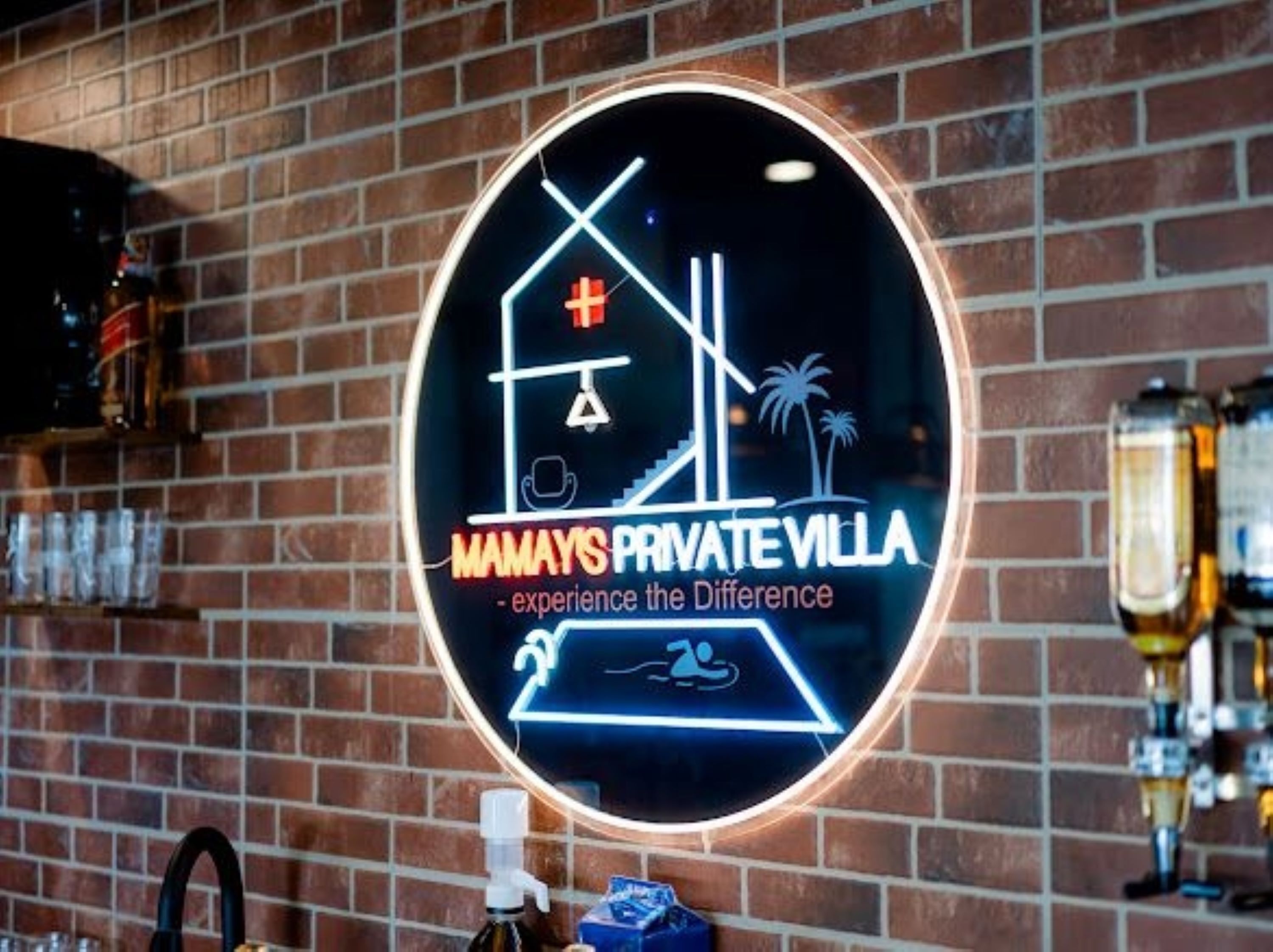 A neon sign advertising 'Mamays Private Villa' with a beach and palm tree iconography.