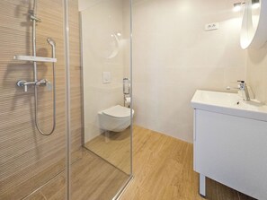 A modern bathroom with a glass shower enclosure, a toilet, and a sink with a mirror. - Vacation home Josipa by Interhome (Vrgorac)