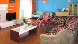 A living room with a sofa, a television, a coffee table, and a chair. - Lina (PUL305) by Interhome (Pula)