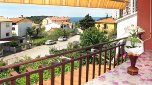 A balcony with a view of a coastal street, a floral tablecloth, and a vase with flowers. - Lina (PUL305) by Interhome (Pula)