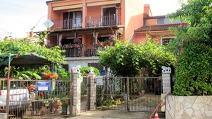 A two-story building with a balcony, a gate, and a stone wall. - Lina (PUL305) by Interhome (Pula)
