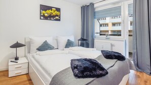Une chambre moderne avec un lit, des tables de chevet, une lampe et une fenêtre avec des rideaux.
