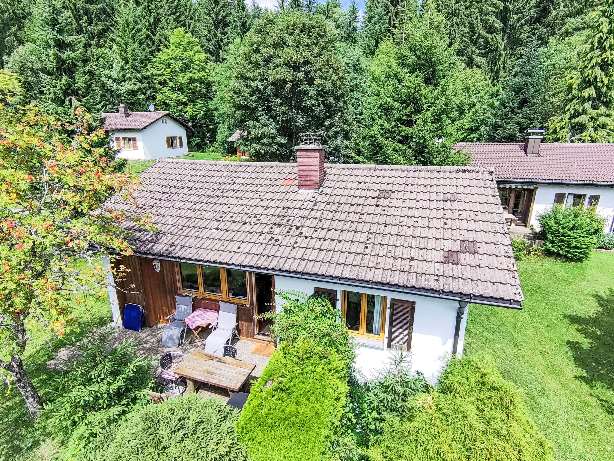 A house with a tiled roof, a wooden deck, and a garden.