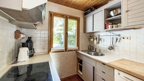 Eine kleine Küche mit Herd, Spüle und Holzschränken.
