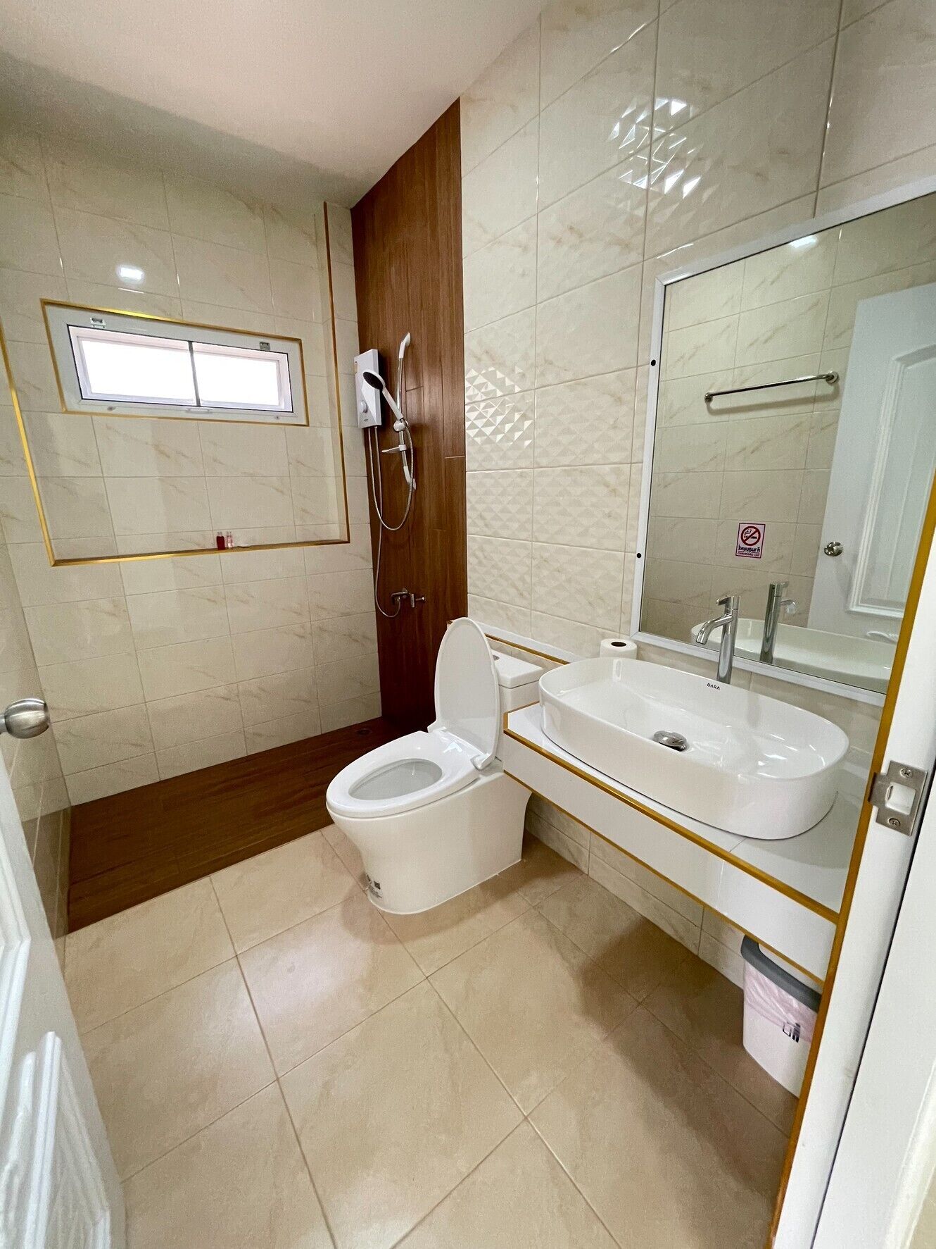 Un baño con inodoro, lavabo, espejo y ducha.
