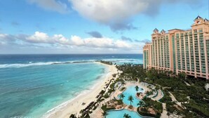 Ein Resort mit einem großen Gebäude, einem Strand und einem Poolbereich.