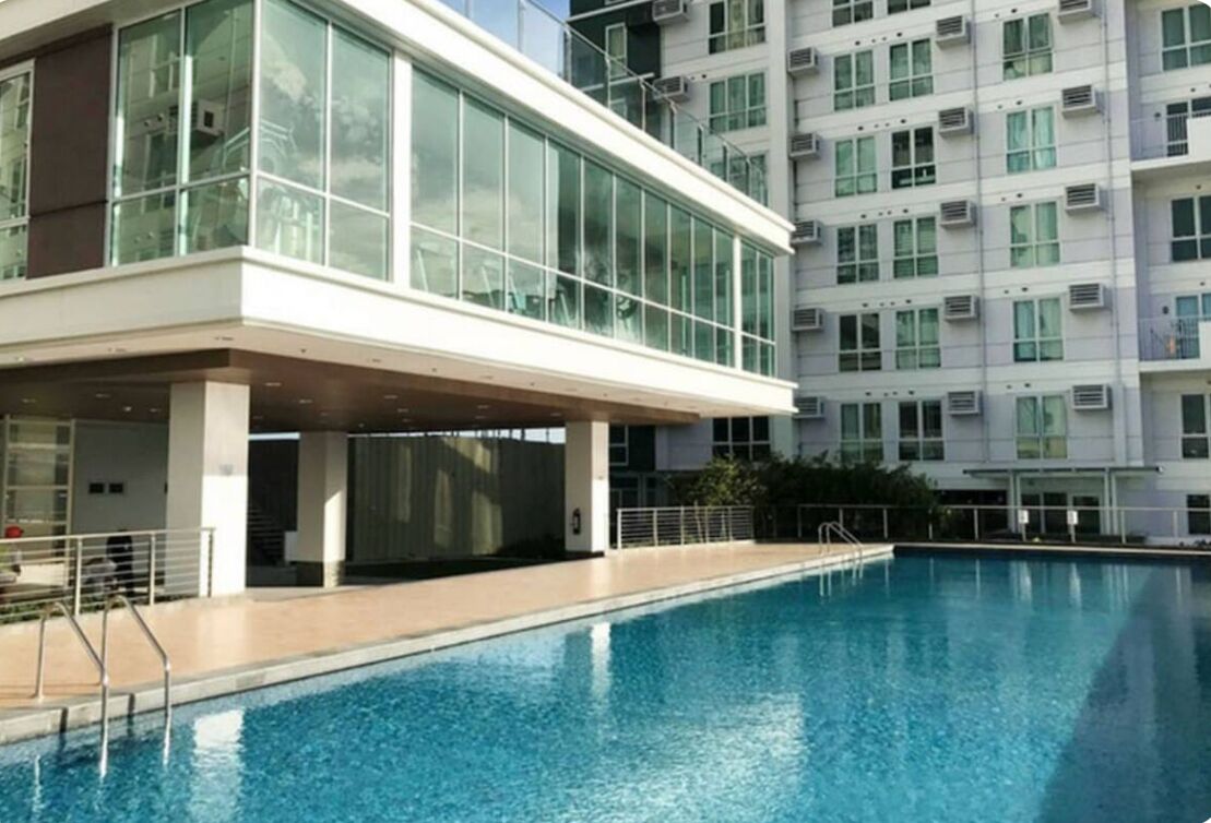 Un edificio moderno con piscina, ampie finestre e condizionatori.