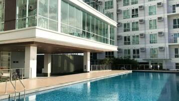 Un edificio moderno con piscina, ampie finestre e condizionatori.