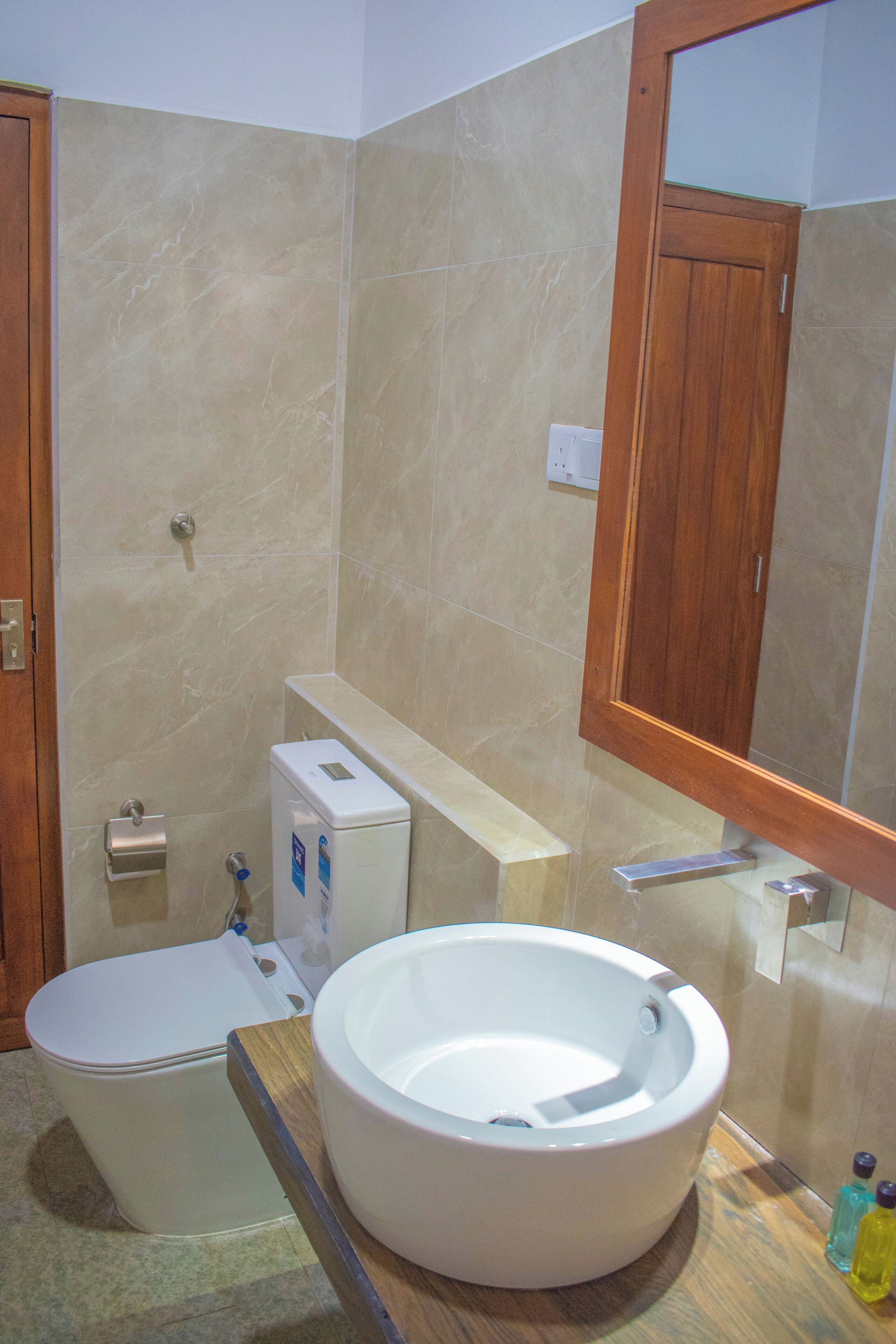 Un baño con inodoro, lavamanos y espejo.