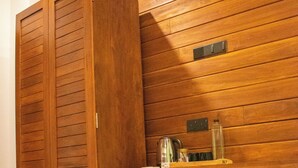 A bathroom with wooden panel walls, a sink with a mirror, and a cabinet. - Caliza Unawatuna by Sea Cloud (Galle)