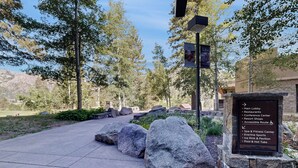 Un sendero de piedra que lleva a un edificio con un letrero que enumera servicios como spa, gimnasio y piscina.