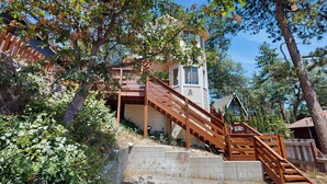 A wooden staircase leading to a house with a small tower-like structure. - Boat, Hike, Fish! Summer Cabin Near Lake Arrowhead (Running Springs)