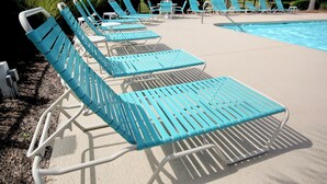 Ett område vid poolen med rader av blå solstolar och en pool.