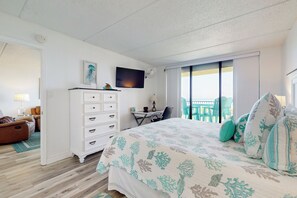 A hotel room with a bed, a desk, a chair, a dresser, a TV, and a balcony with a view. - Resort Perks & Gulf Views: Suntide III - Unit 304 (South Padre Island)