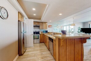 A modern kitchen with wooden cabinets, stainless steel appliances, and a large island. - All-Suite 3BR, Gulf Views: Suntide III - Unit 208 (South Padre Island)