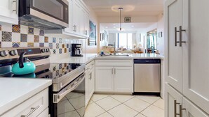 A modern kitchen with white cabinets, a stainless steel stove, and a dishwasher. - 2BR Penthouse Paradise: Suntide III - Unit 1202 (South Padre Island)