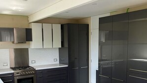 Una cucina moderna con mobili scuri, un piano cottura in acciaio inossidabile e un ripiano in granito.