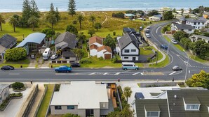 Un quartiere residenziale con case, una strada e una spiaggia sullo sfondo.