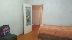A bedroom with a bed, a chair, and a door leading to another room. - Tabriz iki (Baku)
