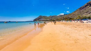 A beach with clear blue water, sandy shore, and a mountainous backdrop. - El Mango House with private pool (Candelaria)