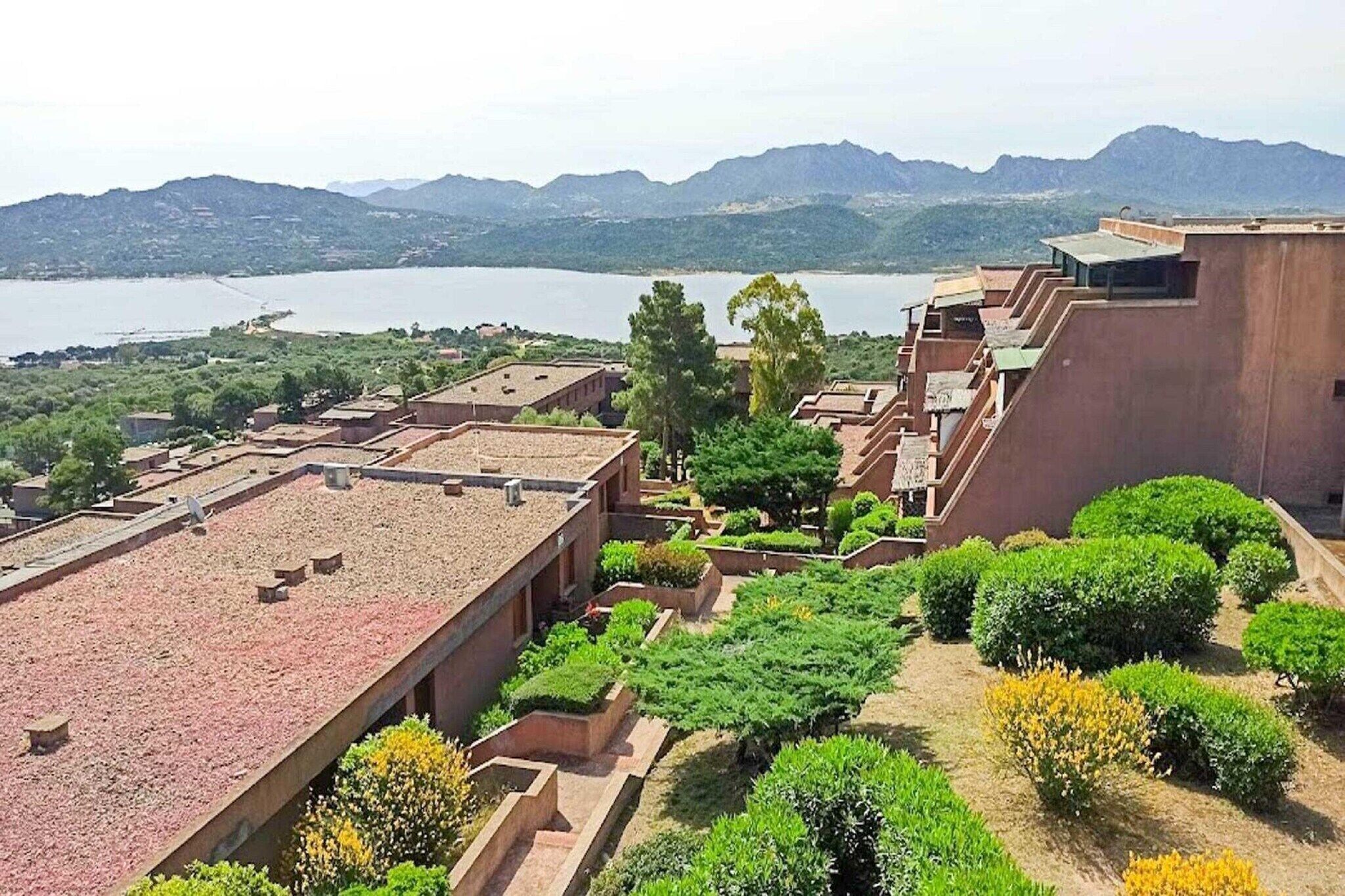 Une vue d’un bâtiment doté d’un toit plat et d’une cour intérieure agrémentée de diverses plantes.