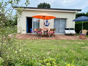 A house with a patio, a table with chairs, and an umbrella. - 10 minutes walk from the sea, brand new wooden house for 4 to 6 people (Houlgate)