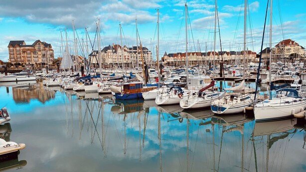 A marina with numerous sailboats docked, surrounded by buildings with traditional architecture. - 10 minutes walk from the sea, brand new wooden house for 4 to 6 people (Houlgate)