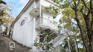 Una villa de dos pisos con un balcón y una escalera que lleva al piso superior.