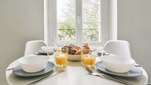 A breakfast table with bowls, glasses of orange juice, and croissants. - Quiet and cosy 2BR in Nanterre - Near La Defense (Nanterre)