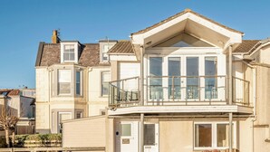 A two-story house with a balcony, a garage, and a visible front door.
