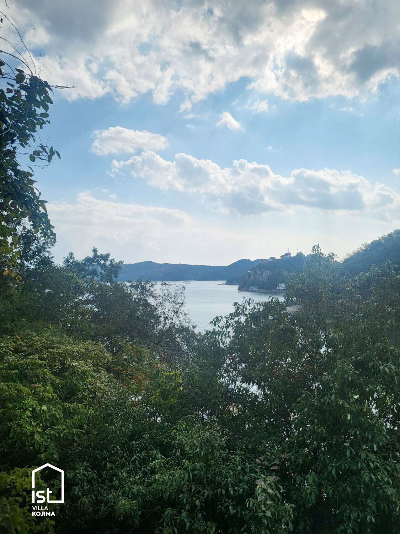 Vue de la villa Kojima, avec un lac et des montagnes en arrière-plan.