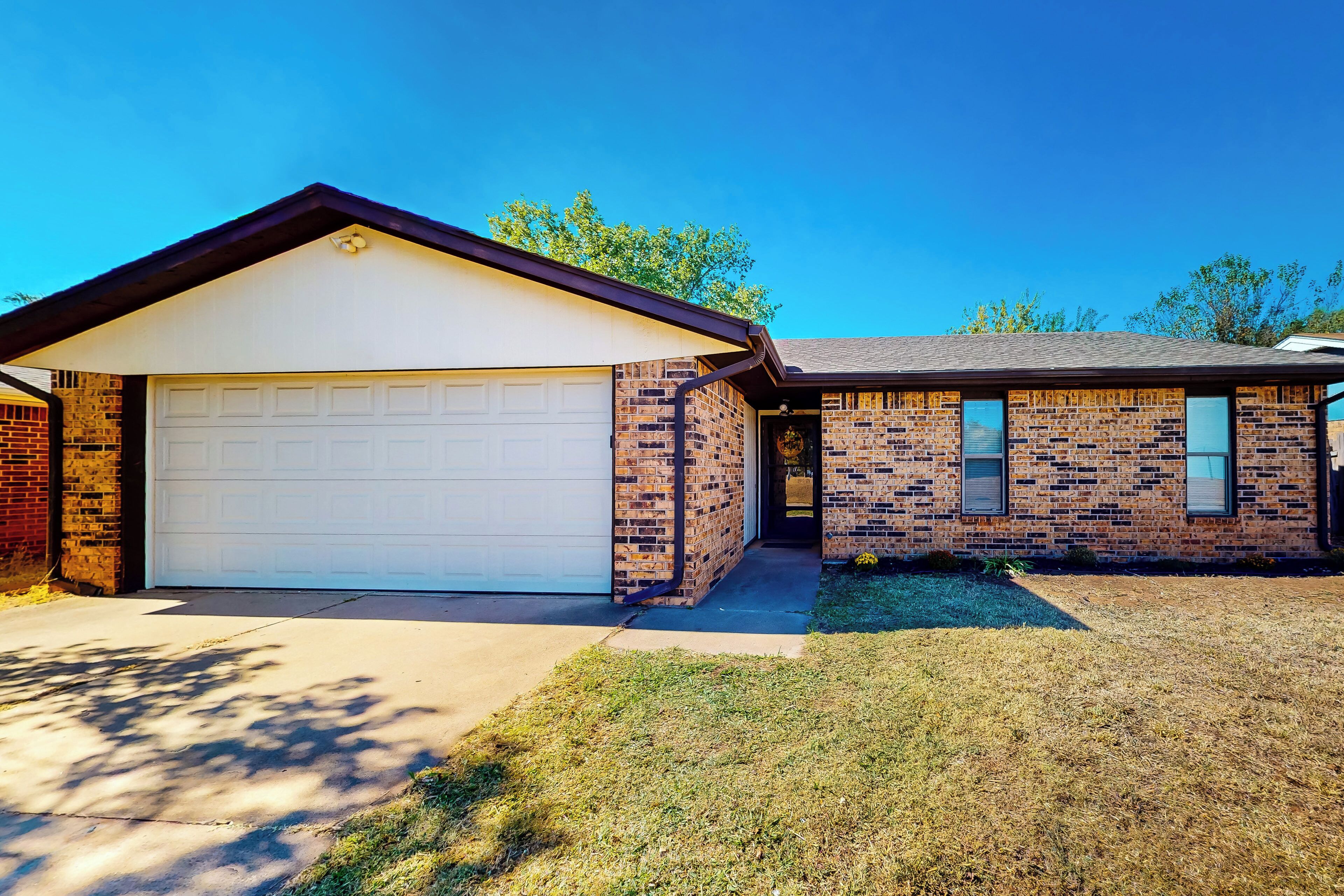 A two-story house with a garage and a brick exterior.