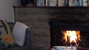 A cozy living room with a fireplace, a sofa with a patterned throw, and a coffee table with books and a decorative bowl. - Self-catering farmhouse on working farm, a peaceful retreat outside of Underberg (Underberg)