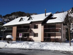 A multi-story building with a snow-covered roof, a no parking sign, and a clear blue sky in the background. - Blumenweg 2/1 Appartement/Fewo 2-Bettwohnung by Interhome (Engelberg)