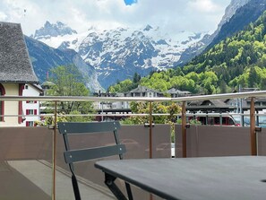 A balcony with a view of snow-capped mountains, a table, and a chair. - Blumenweg 2/1 Appartement/Fewo 2-Bettwohnung by Interhome (Engelberg)