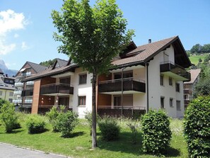 A multi-story residential building with balconies, surrounded by greenery and a clear sky. - Blumenweg 2/1 Appartement/Fewo 2-Bettwohnung by Interhome (Engelberg)