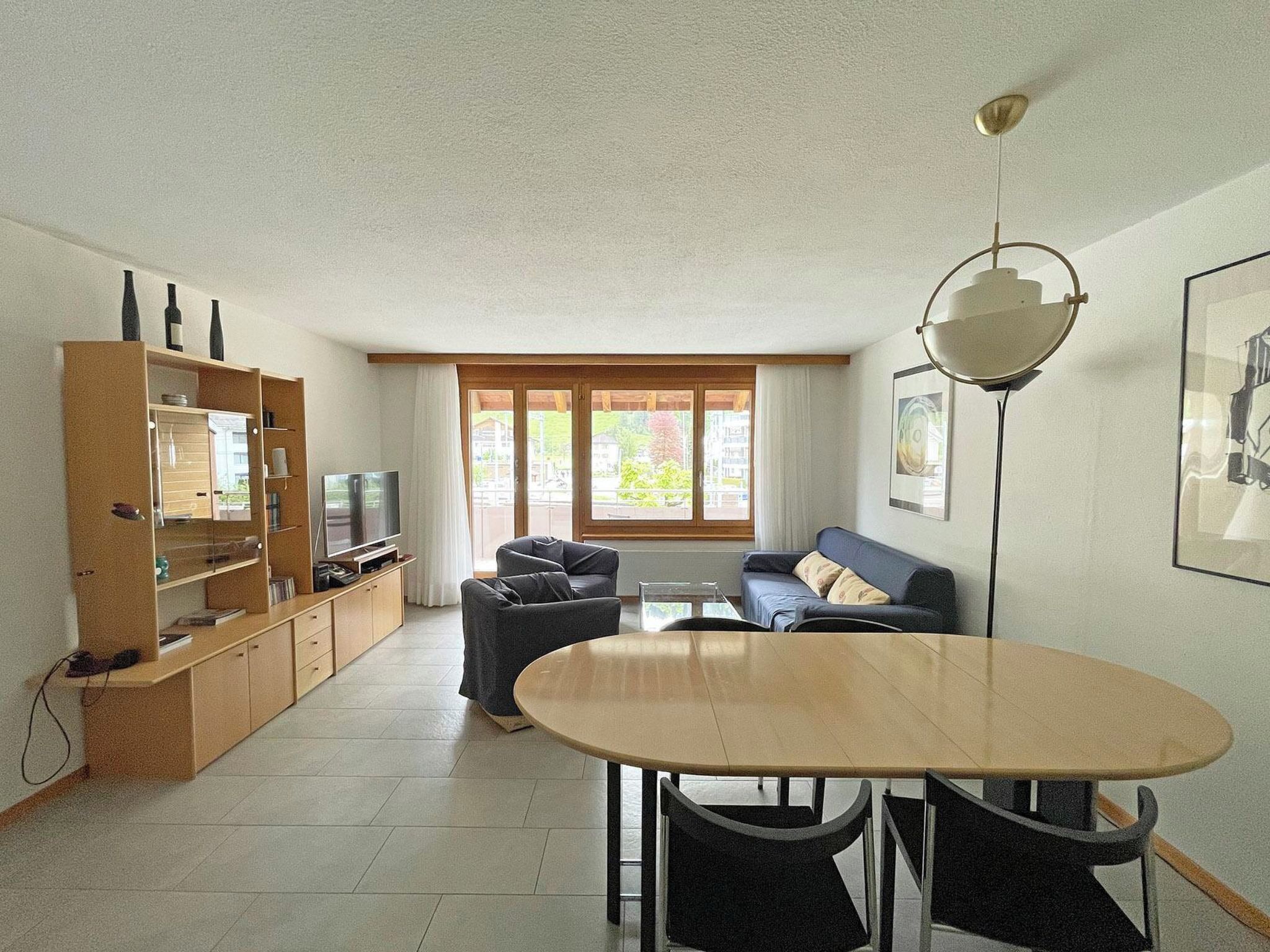 A living room with a TV, sofa, and dining table.