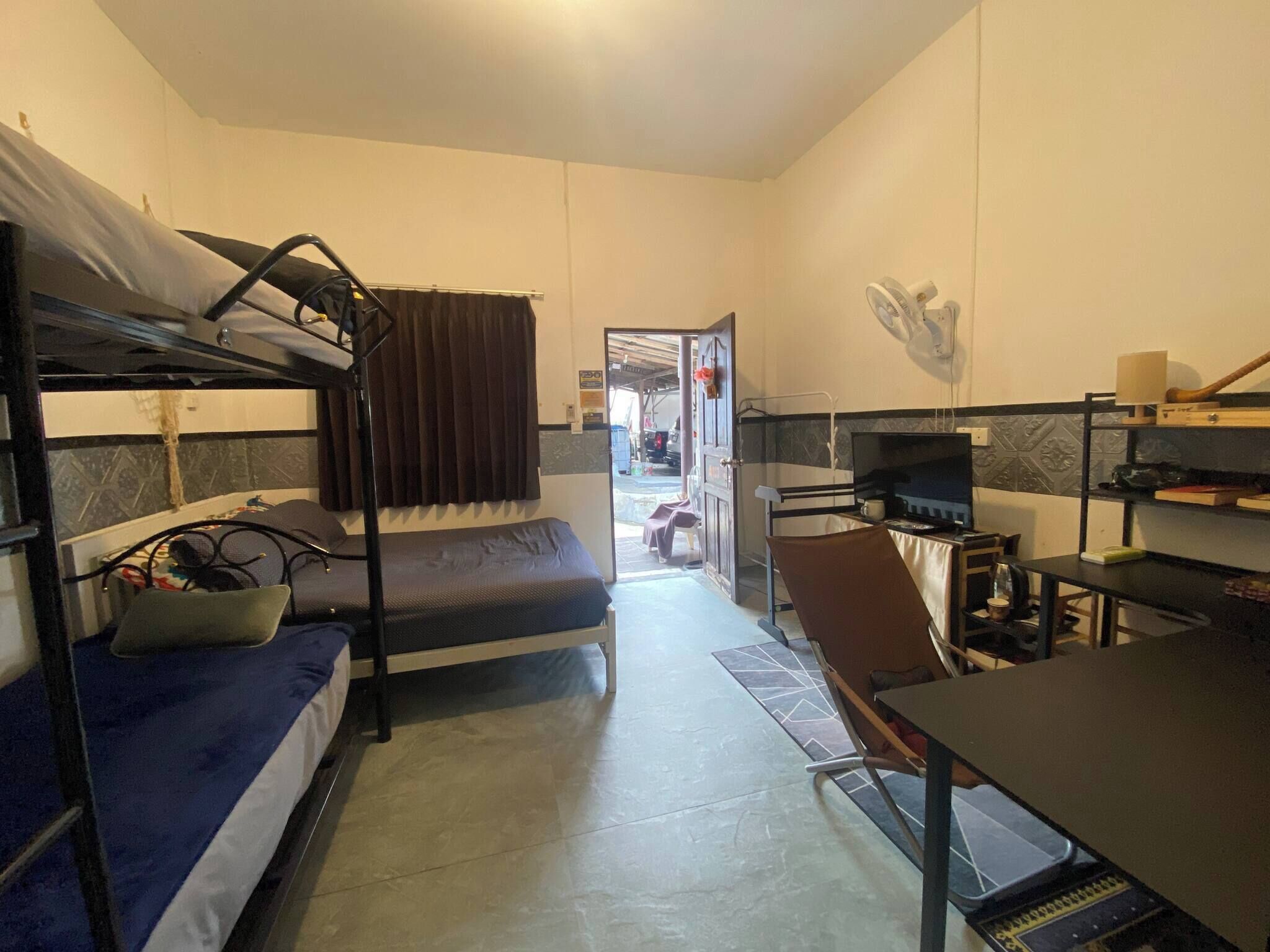 A compact room with bunk beds, a desk, and a chair.