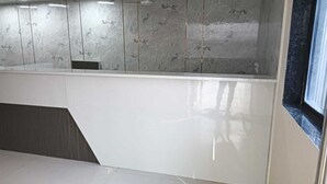 A modern interior with a white countertop, a dark floor, and a marble backsplash. - Hotel Empire (Vapi)