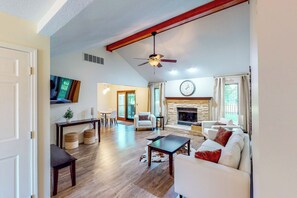 A spacious living room with a fireplace, a ceiling fan, and a large clock on the wall. - Dog-Friendly Yard! Family Retreat in Fort Wayne (Fort Wayne)