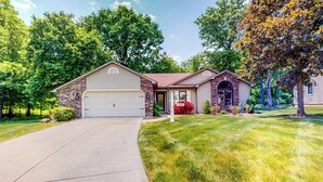 A two-story house with a garage, a front porch, and a well-maintained lawn. - Dog-Friendly Yard! Family Retreat in Fort Wayne (Fort Wayne)