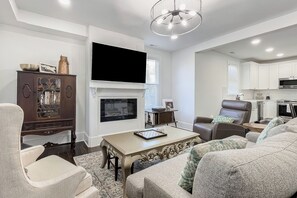 A modern living room with a fireplace, a flat-screen TV, and a kitchen area. - Pets Welcome! Family-Friendly Retreat in Culpeper (Culpeper)