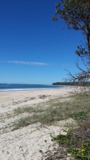 A beach with clear skies and a distant shoreline.