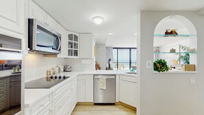Una cucina moderna con mobili bianchi, un forno a microonde integrato e una lavastoviglie.