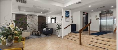 A spacious living area with a sofa, coffee table, and decorative plants.