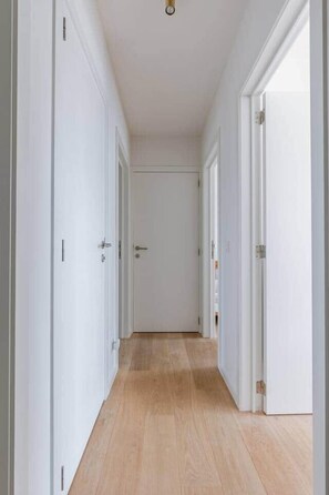 A hallway with white doors and wooden flooring. - Brand new house Sable d'Or  - Oostduinkerke (Koksijde)