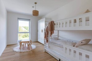 A bedroom with bunk beds, a dining table, and a large window. - Brand new house Sable d'Or  - Oostduinkerke (Koksijde)