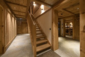 A wooden staircase in a building with stone flooring and wooden walls. - Panorama Deluxe Mountain Hideaway House (Tschagguns)